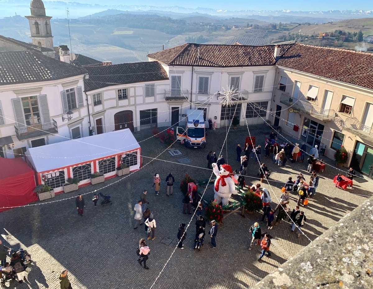 Families playing traditional wooden games in the piazza at Govone.