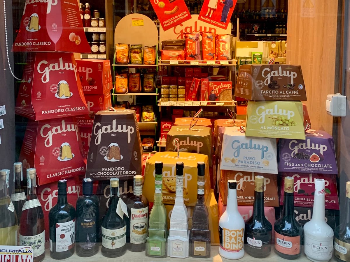 A festive shop window display in Turin featuring Galup panettone and Piedmontese liquors.