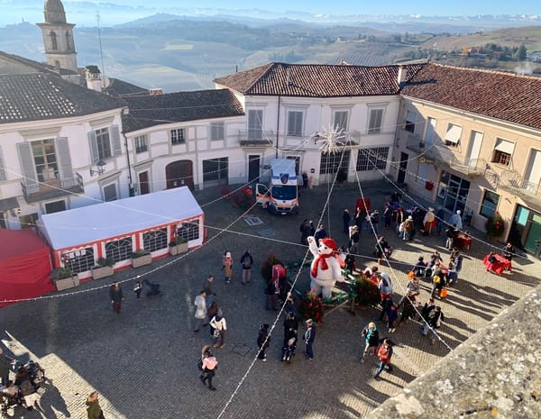 Families playing traditional wooden games in the piazza at Govone.
